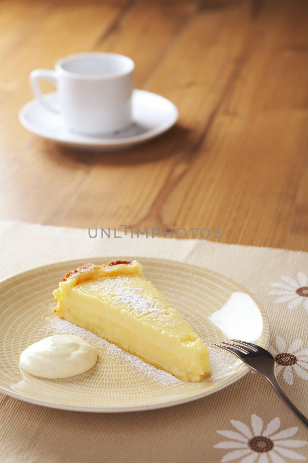 Home made icing sugar topped lime tart with cream on the table