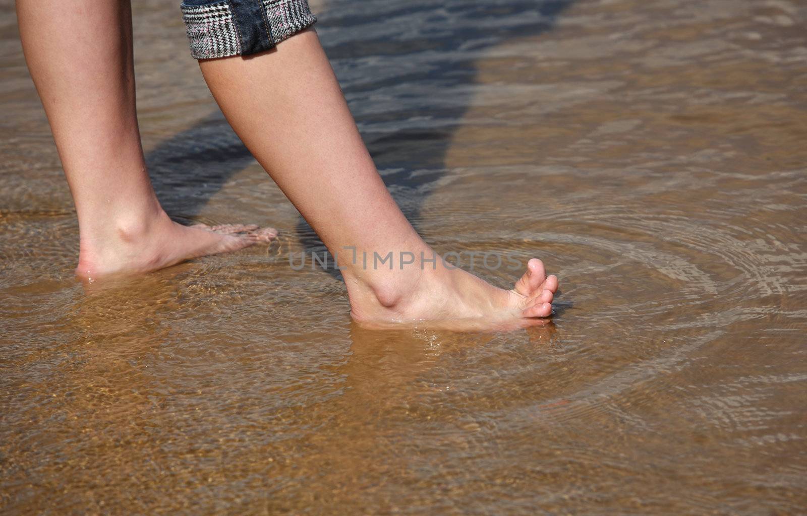 Female legs in transparent water