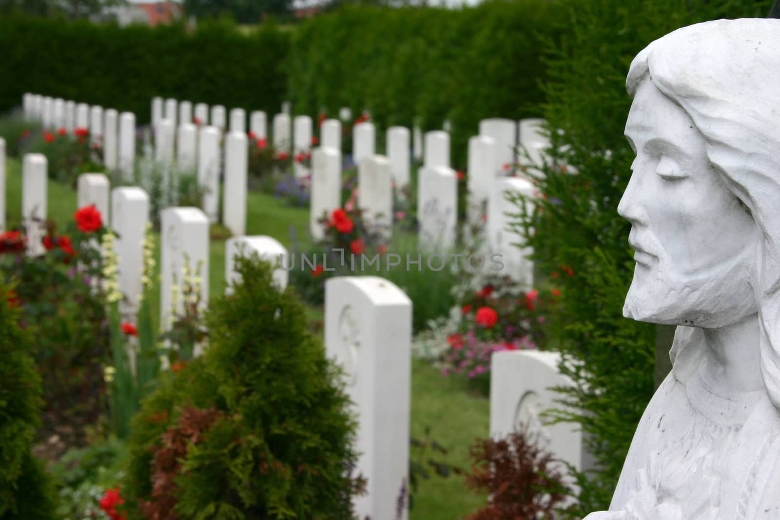 White gravestones of a WWI with statue of Jesus Christ in front