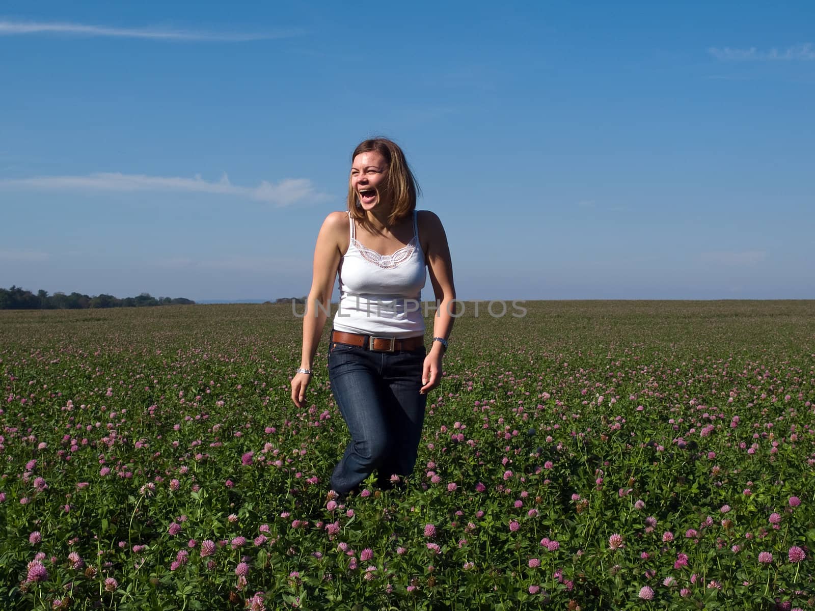 Beautiful attractive young happy woman girl in a flowers field
