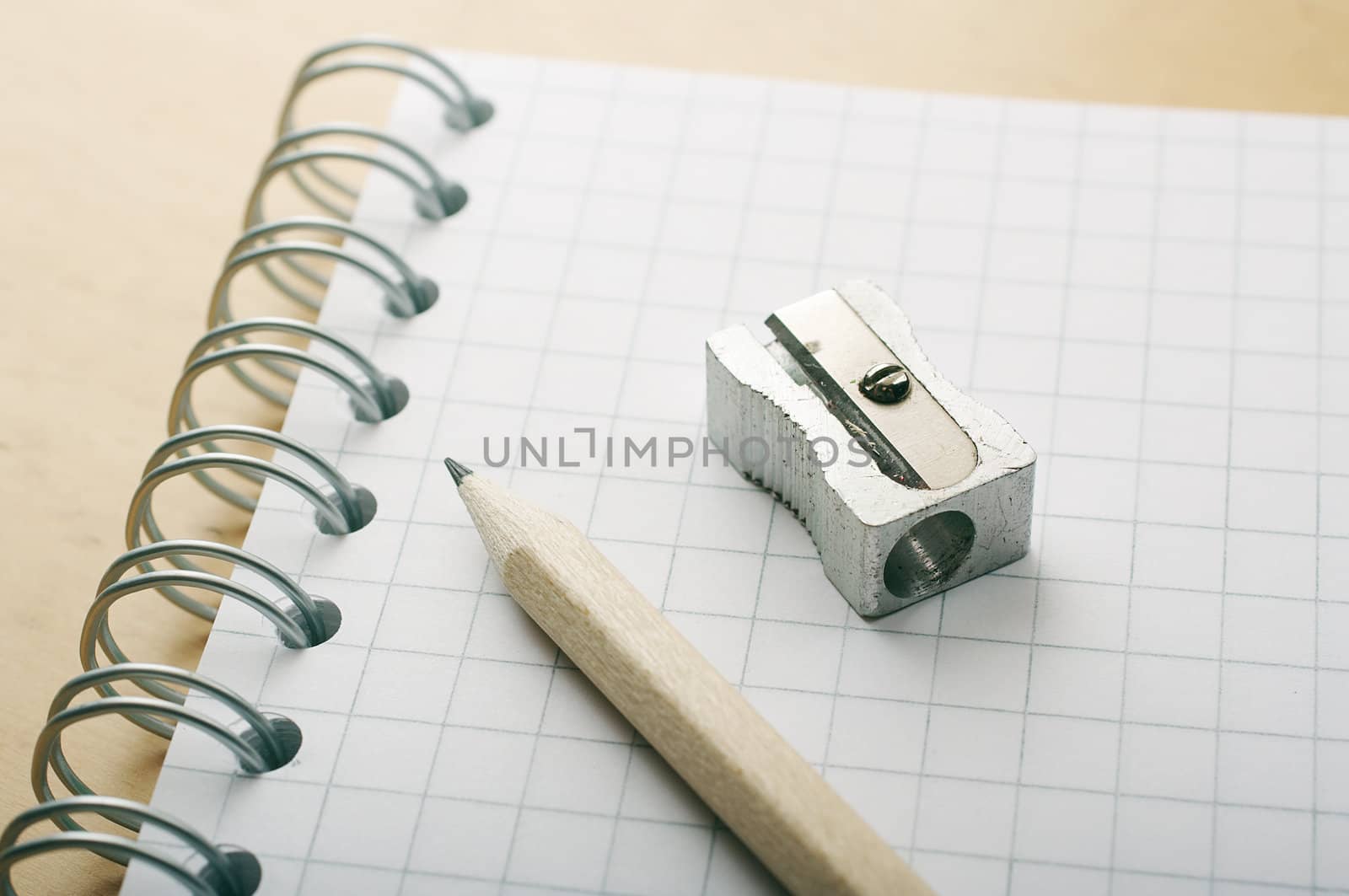 pencil and sharpener over a white checkered binder