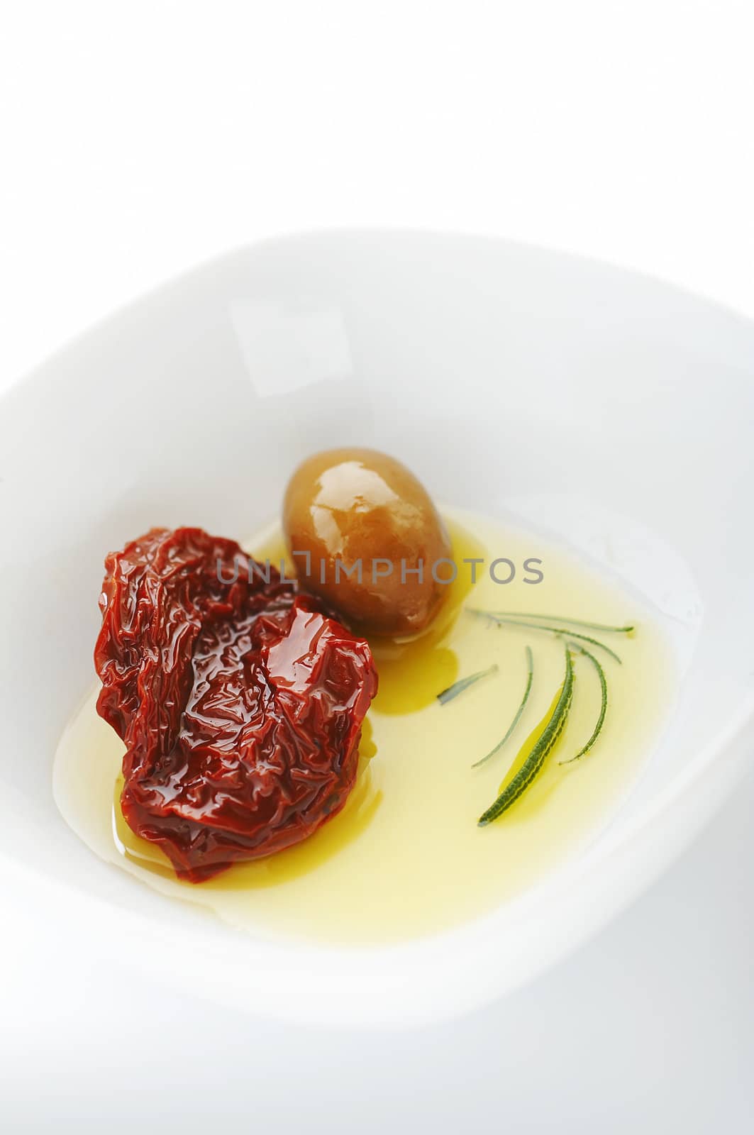 Olive and sun dried tomato with olive oil on the white plate
