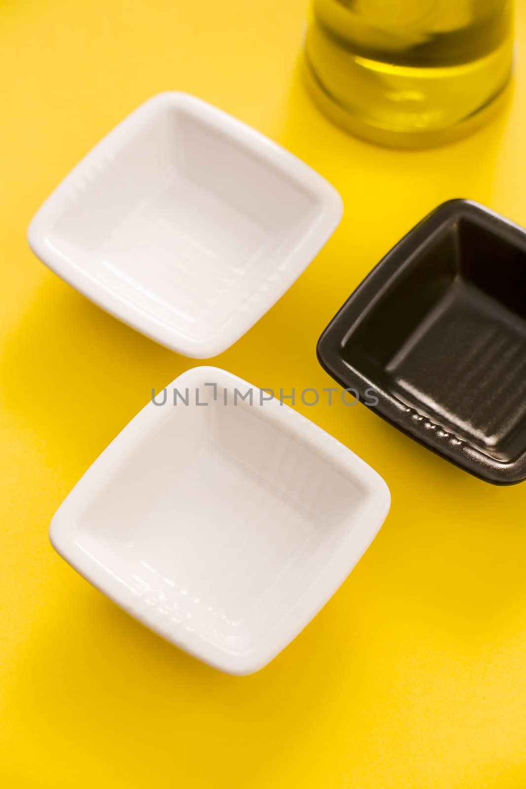 Empty vases and olive oil bottle over a yellow background