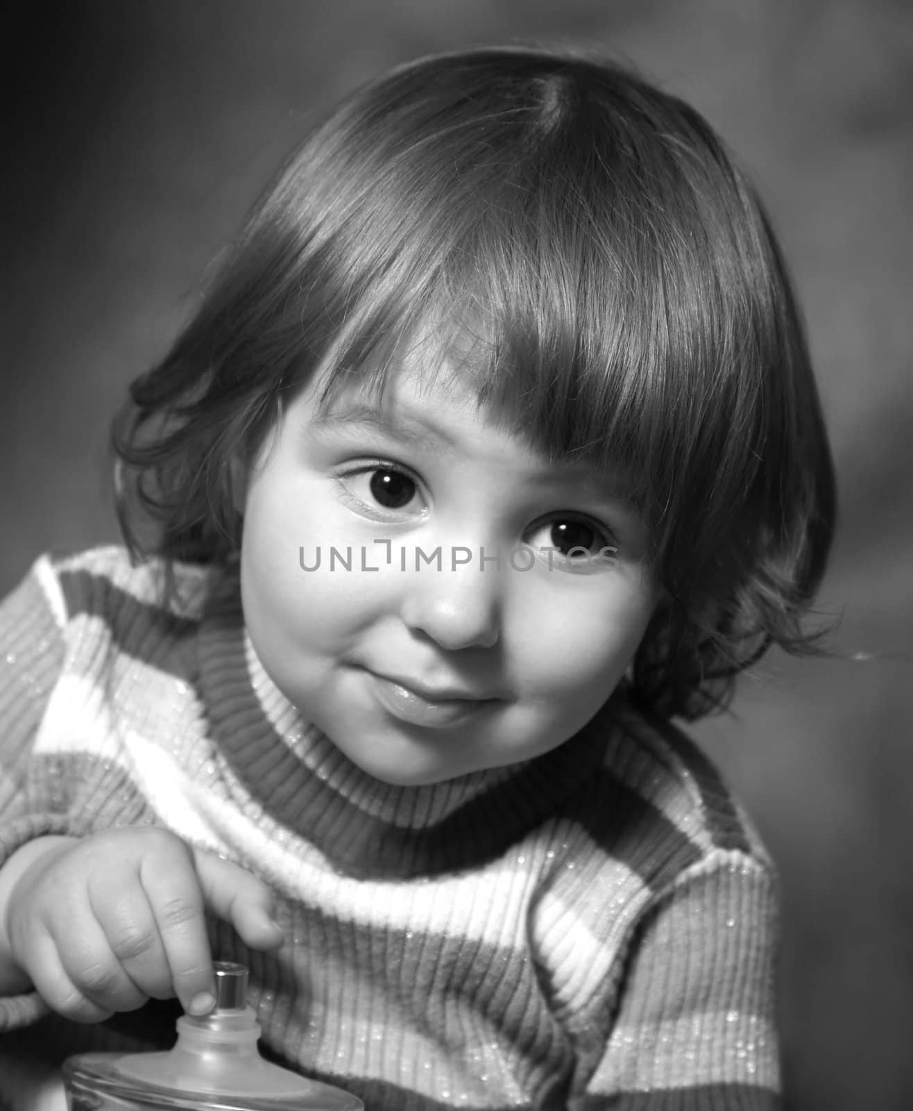 Portrait of the two-year-old girl with a bottle in hands. b/w