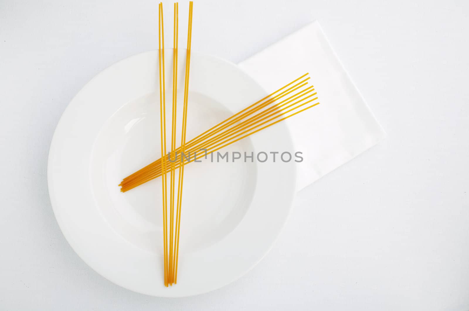 Abstract uncooked red (tomato) pasta on the white plate