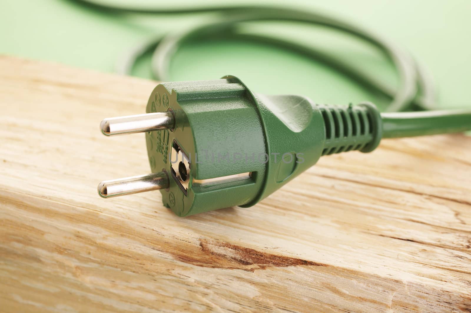 Green energy concept (green energy plug on the wood)