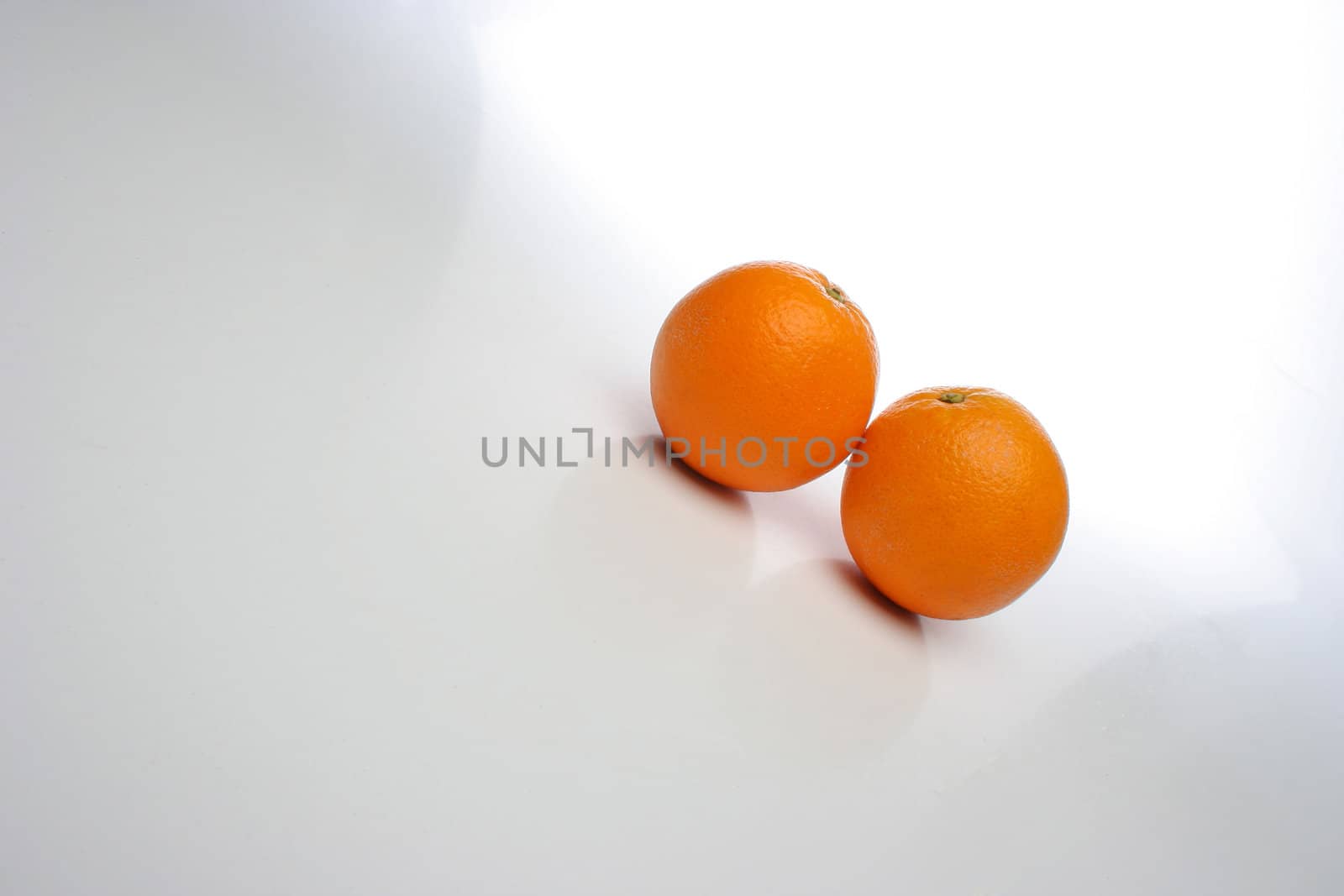 A pair of juicy oranges, side by side over a white background, big space for text and design elements. Look at my gallery for more fruits and vegetables