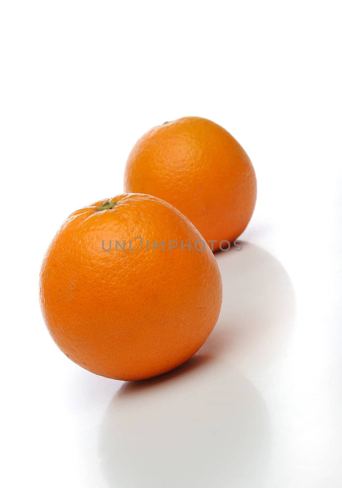 A pair of juicy oranges, one on front and one  backwards over a white background. Look at my gallery for more fruits and vegetables
