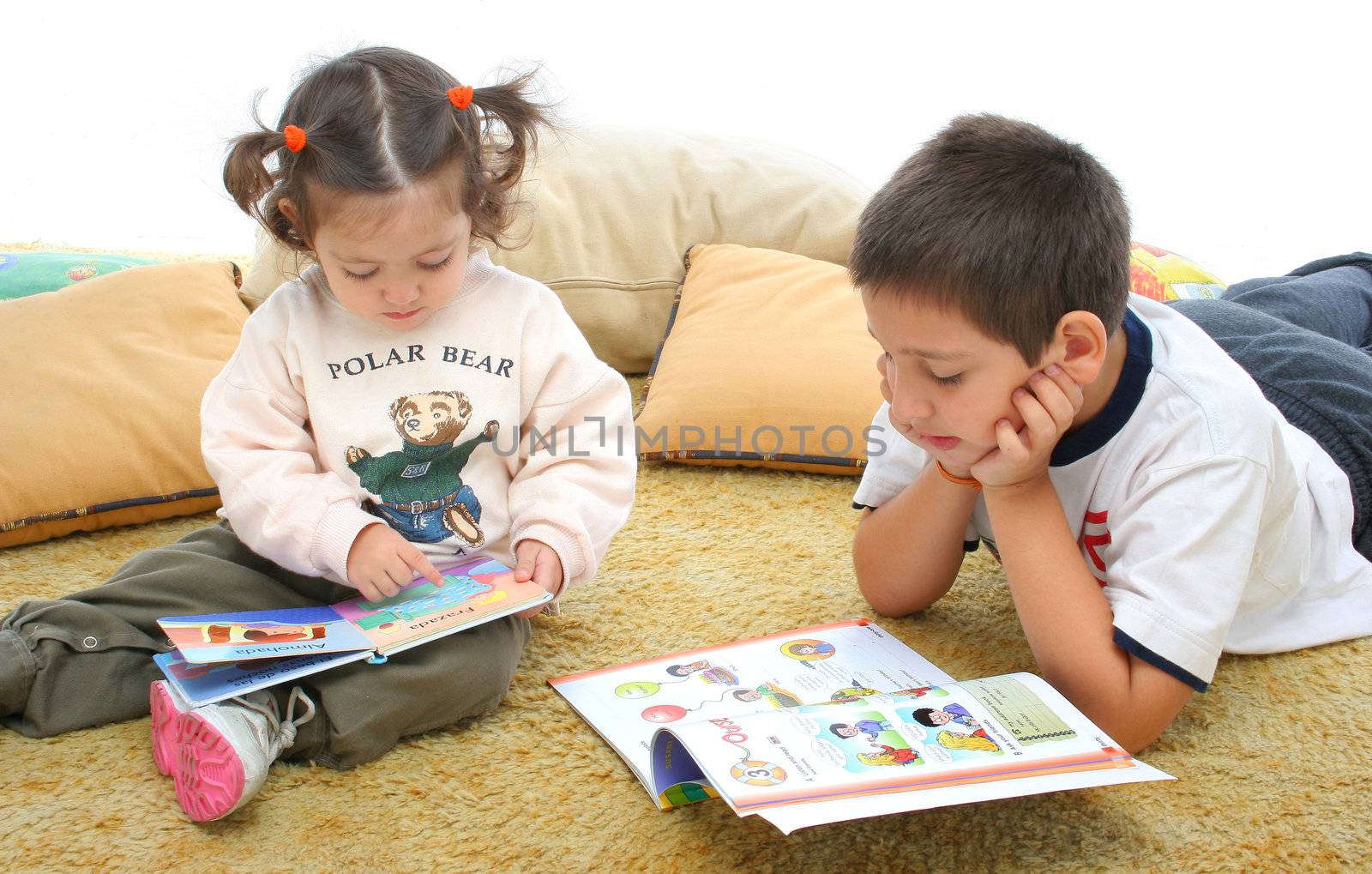 Brother and sister reading books on the floor by Erdosain