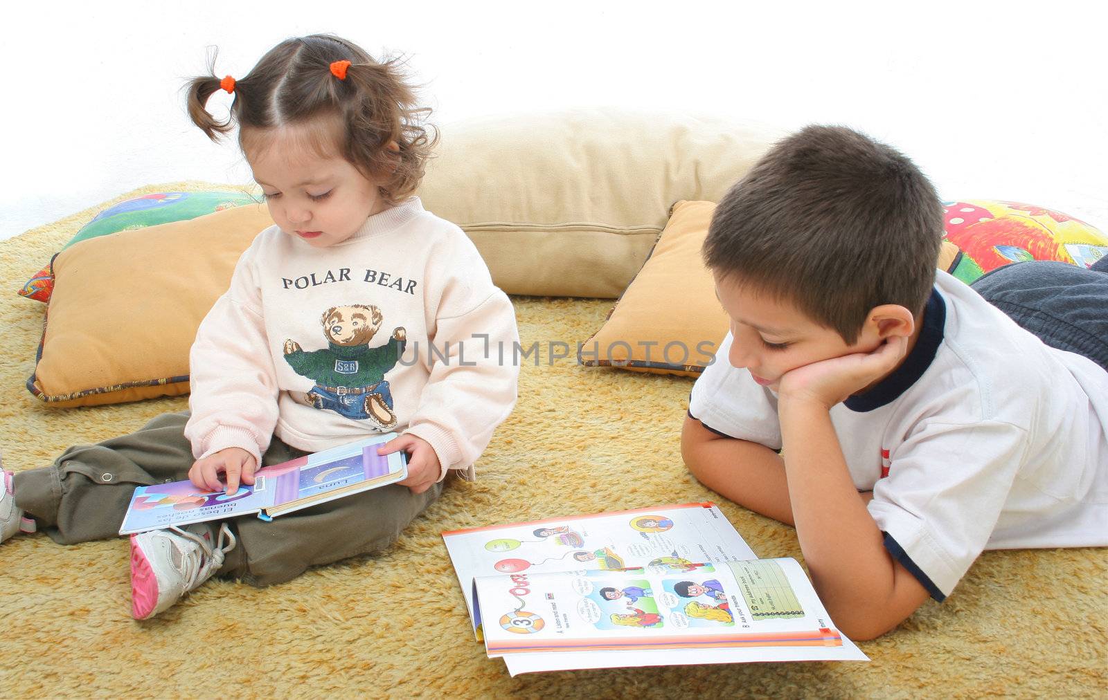 Brother and sister reading books on the floor by Erdosain