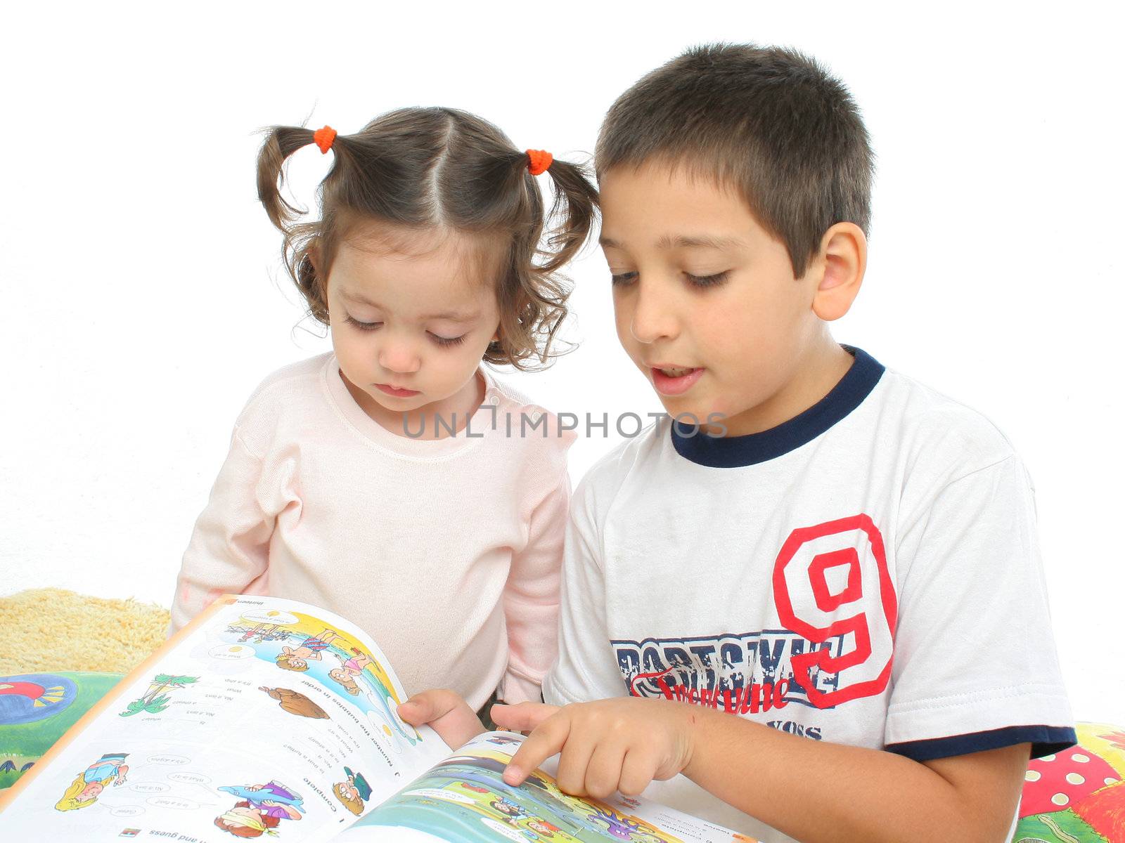 Brother and sister reading a book on the floor by Erdosain