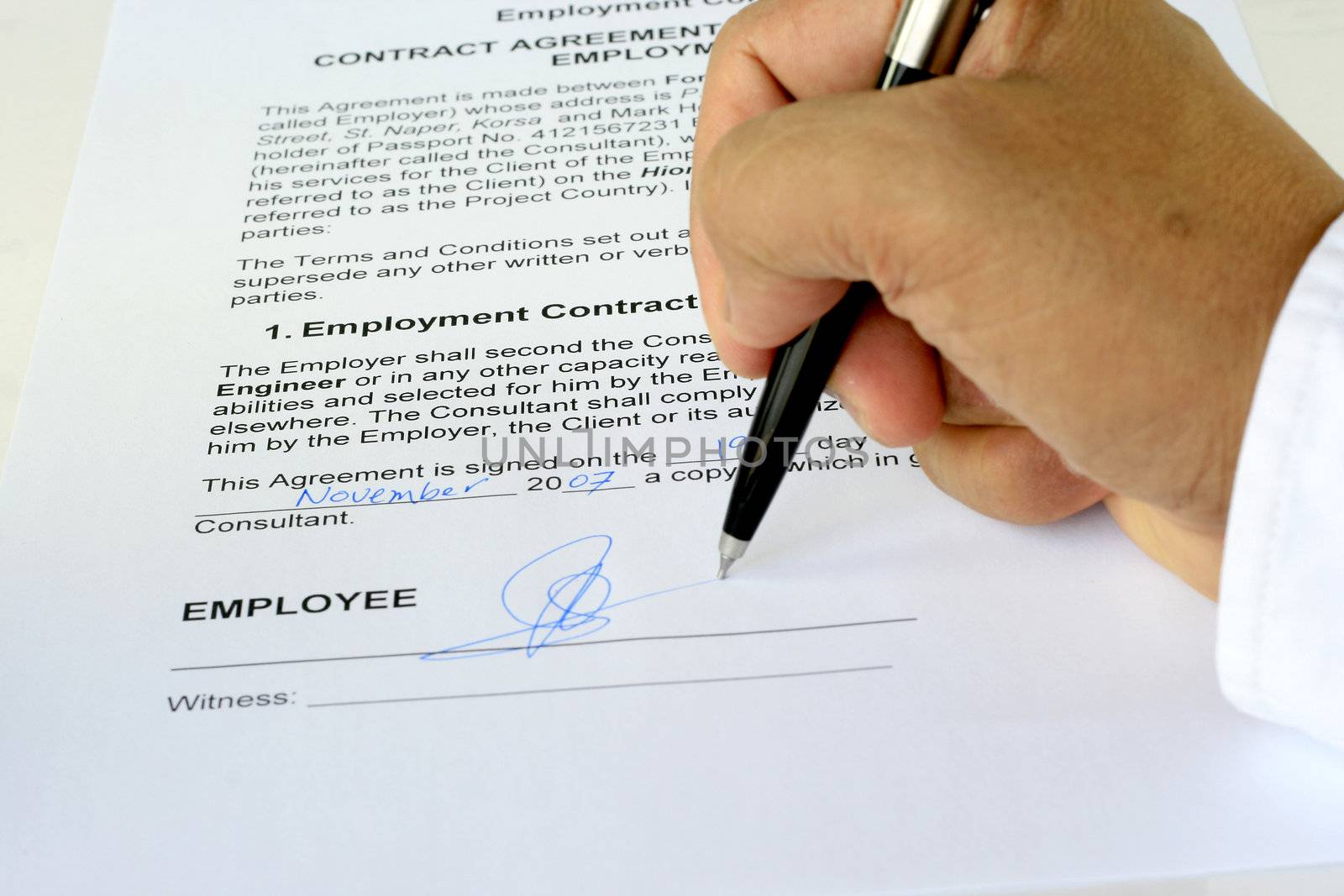 employment contract agreement being signed showing the form, hand and pen
