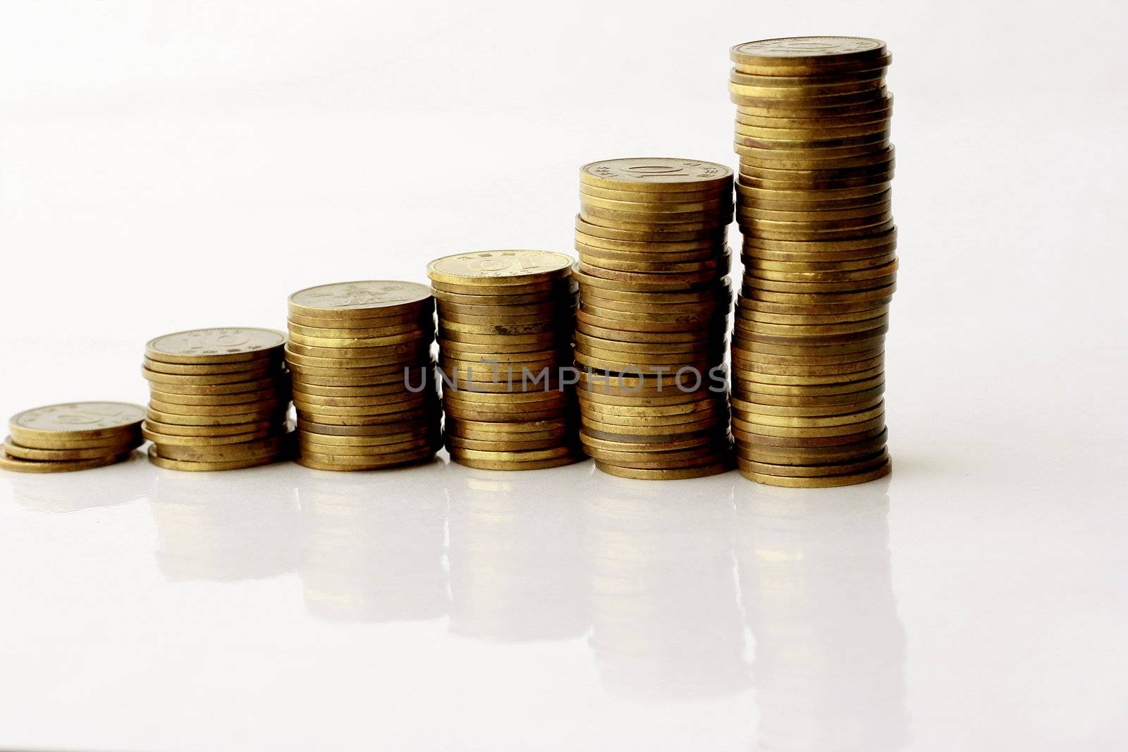 Business Concept - Coins stack up getting highier in a white background