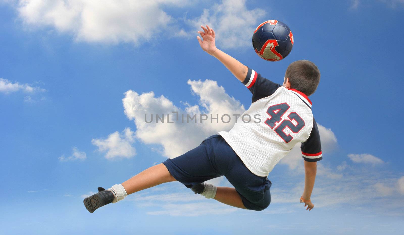 Kid playing soccer outside by Erdosain