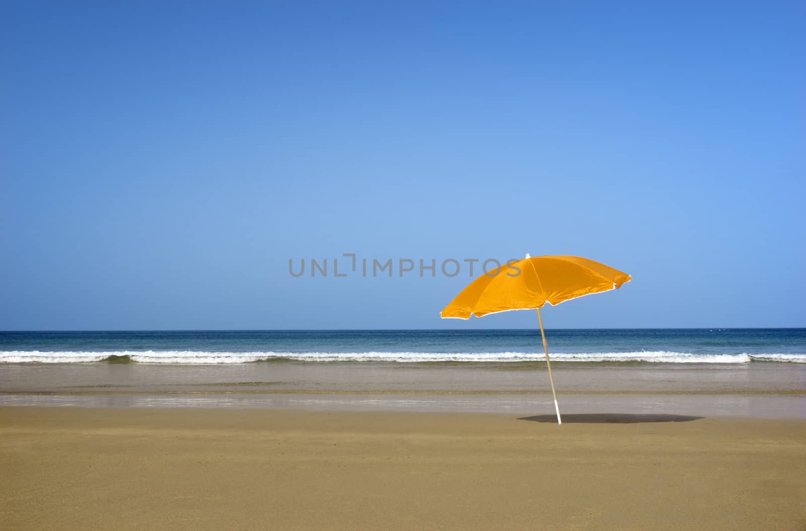 Beautiful tranquil beach with a orange hat on the sand