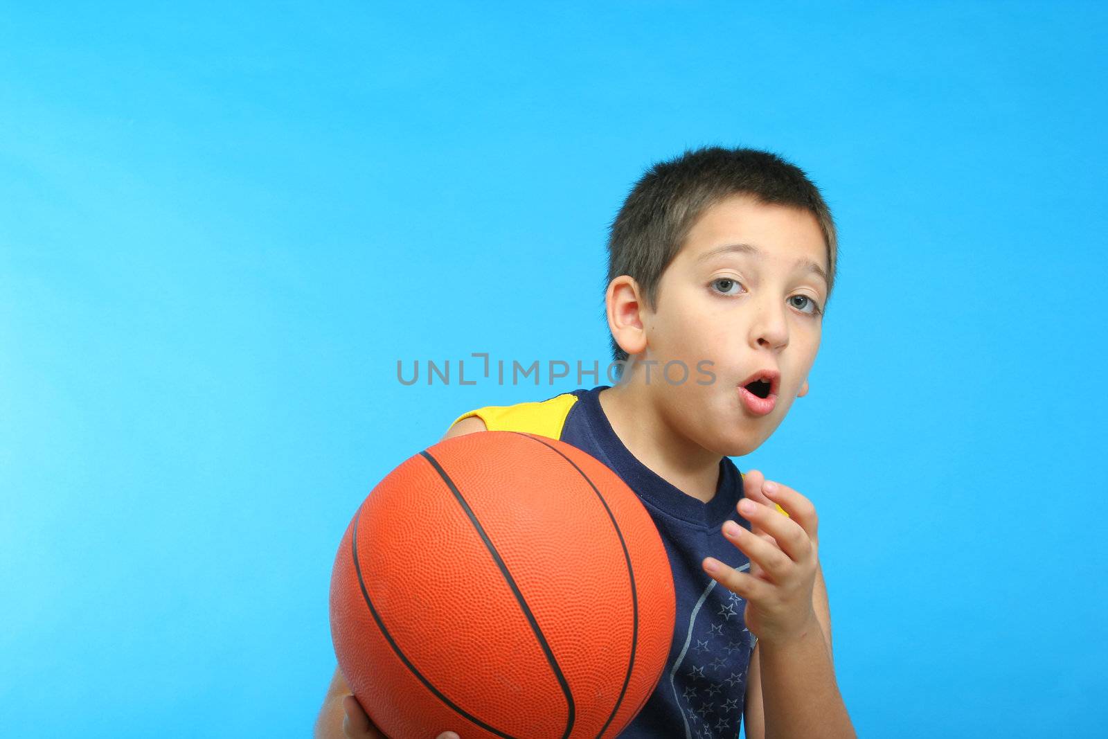 Boy playing basketball blue background. From my sport series.