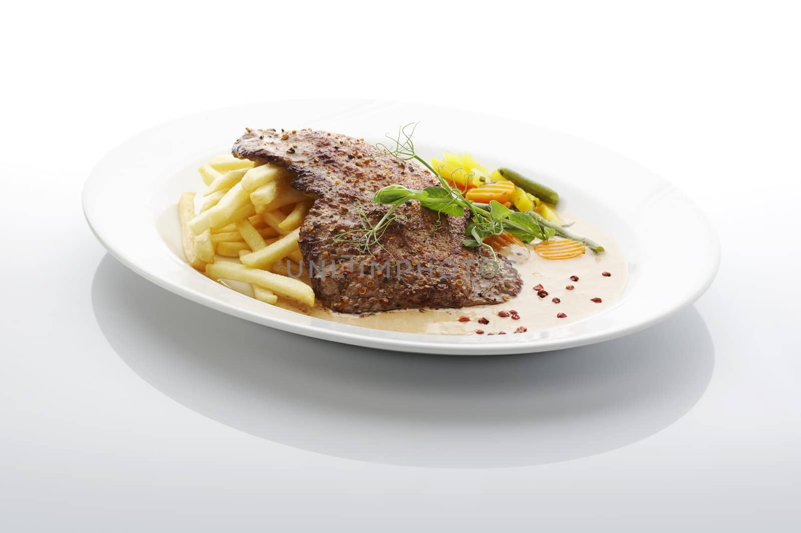 Steak and fries on the plate over white background