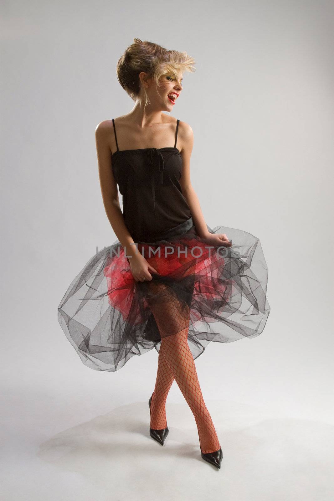 Beautiful woman in diaphanous skirt on grey background