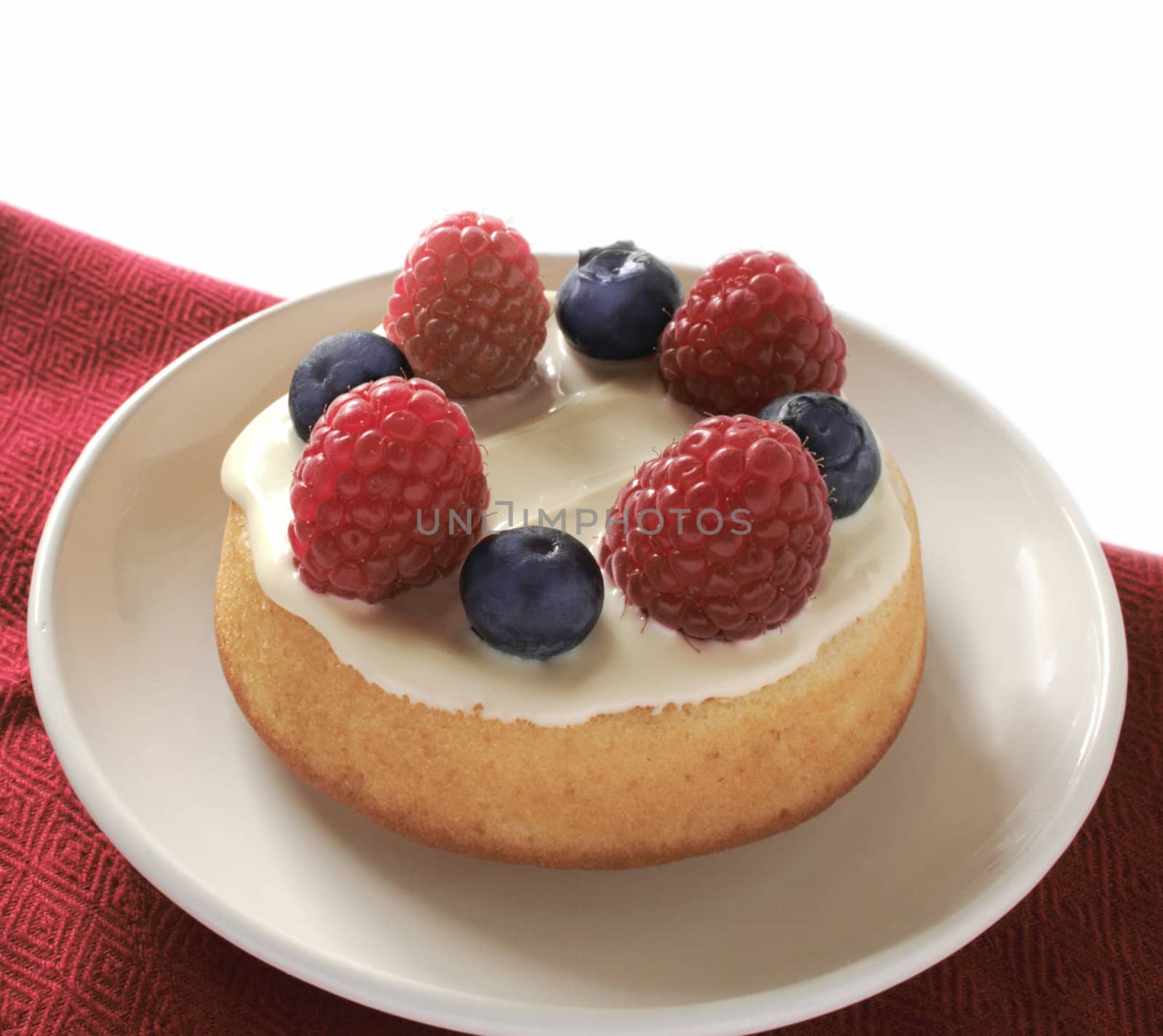 individual-sized dessert topped with white chocolate, fresh raspberries and blueberries
