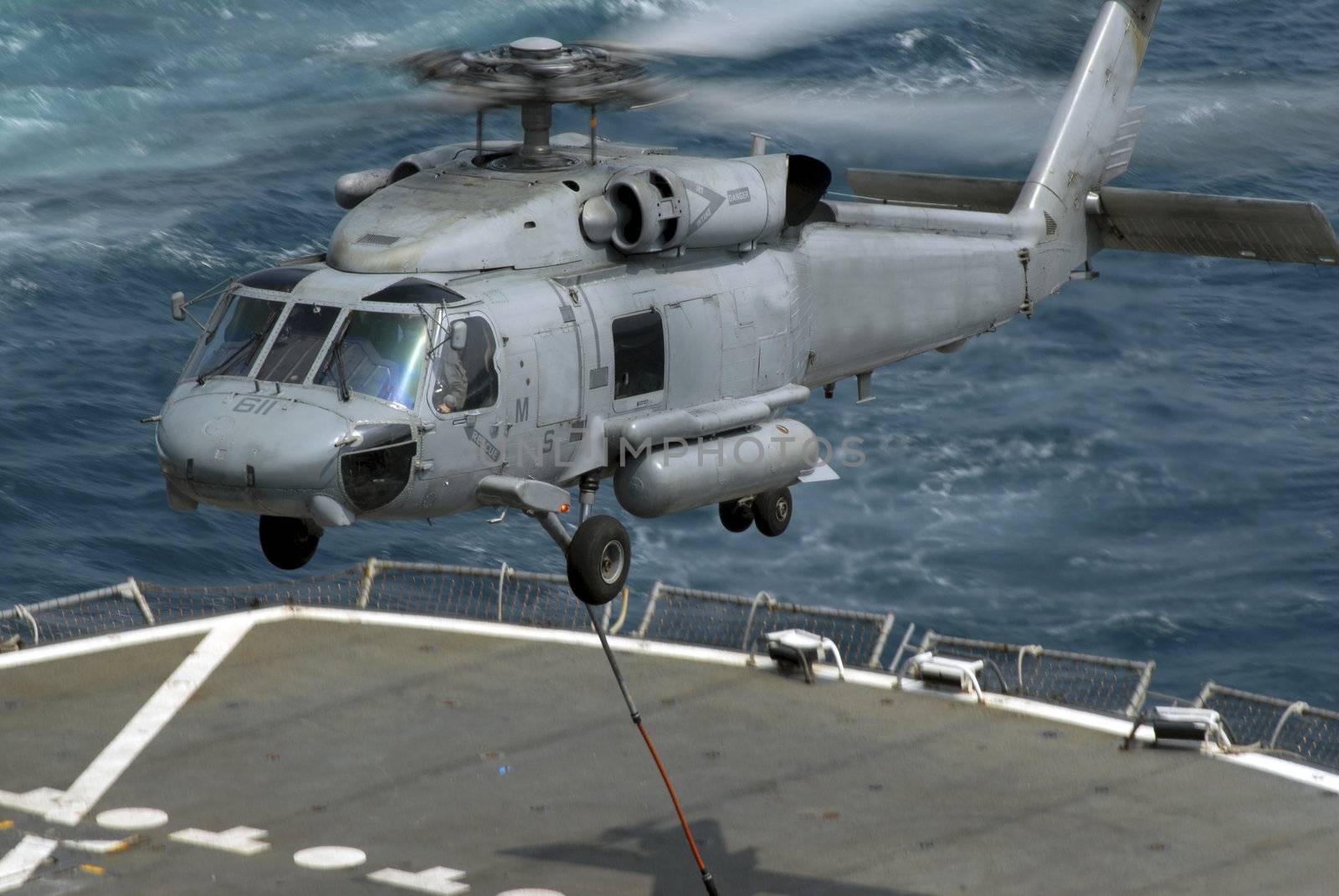 An SH-60 Seahawk lifts cargo from a supply ship