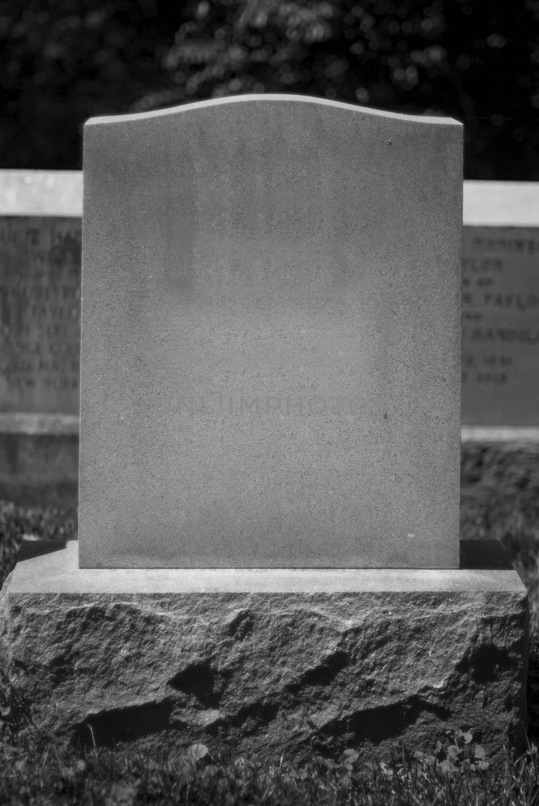 A blank tombstone stands in a cemetary