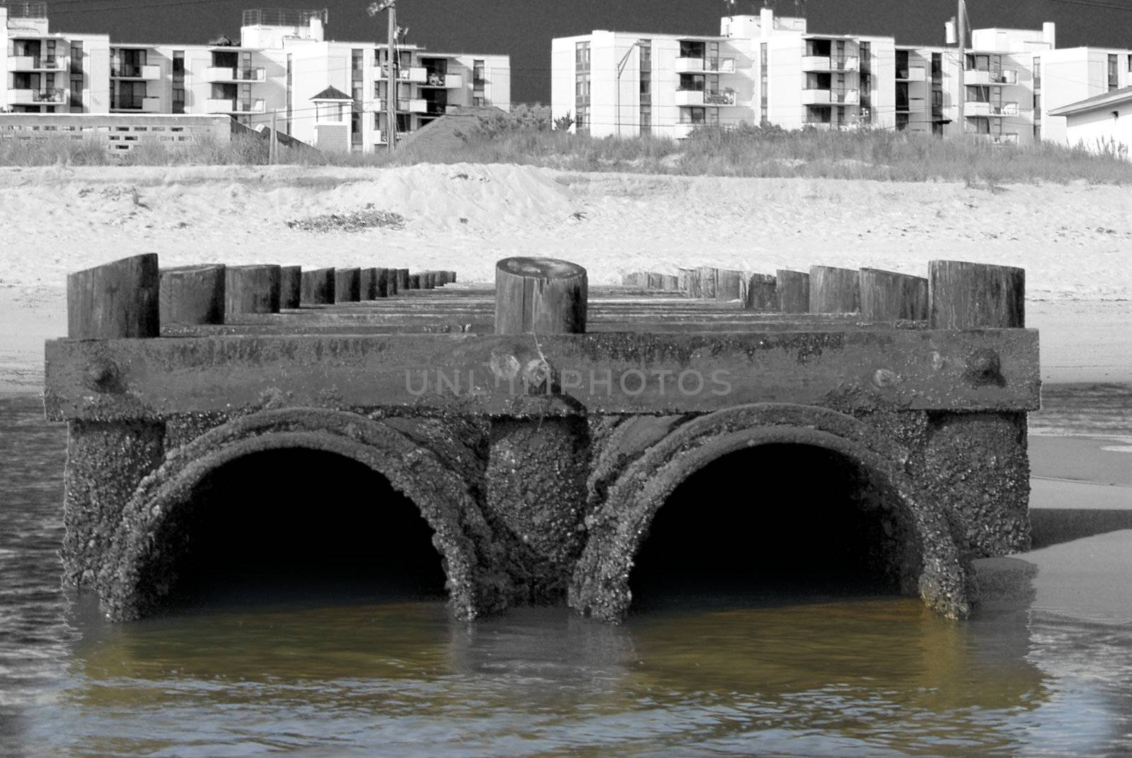 a gritty and grainy image of pollution from sewer pipes empties into the ocean