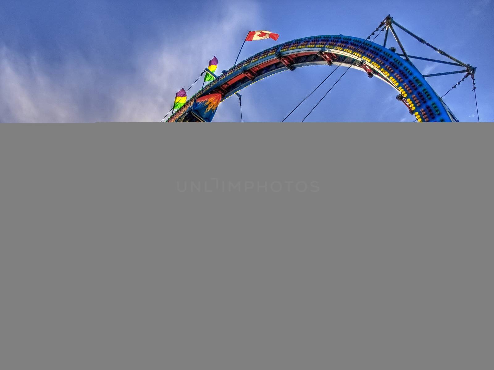 A rollercoaster loop at a fair in mid summer.