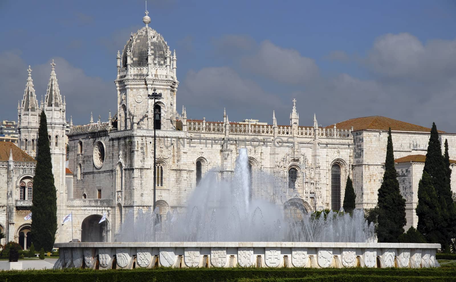 A classic European Monastery with a beautiful fountain in front of it