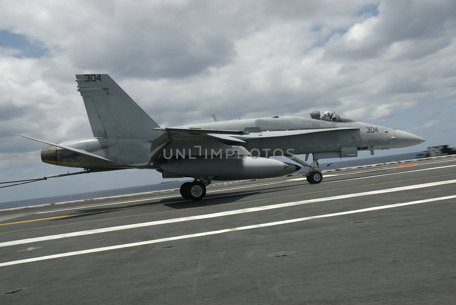 An F-18 Hornet lands aboard a nuclear powered aircraft carrier