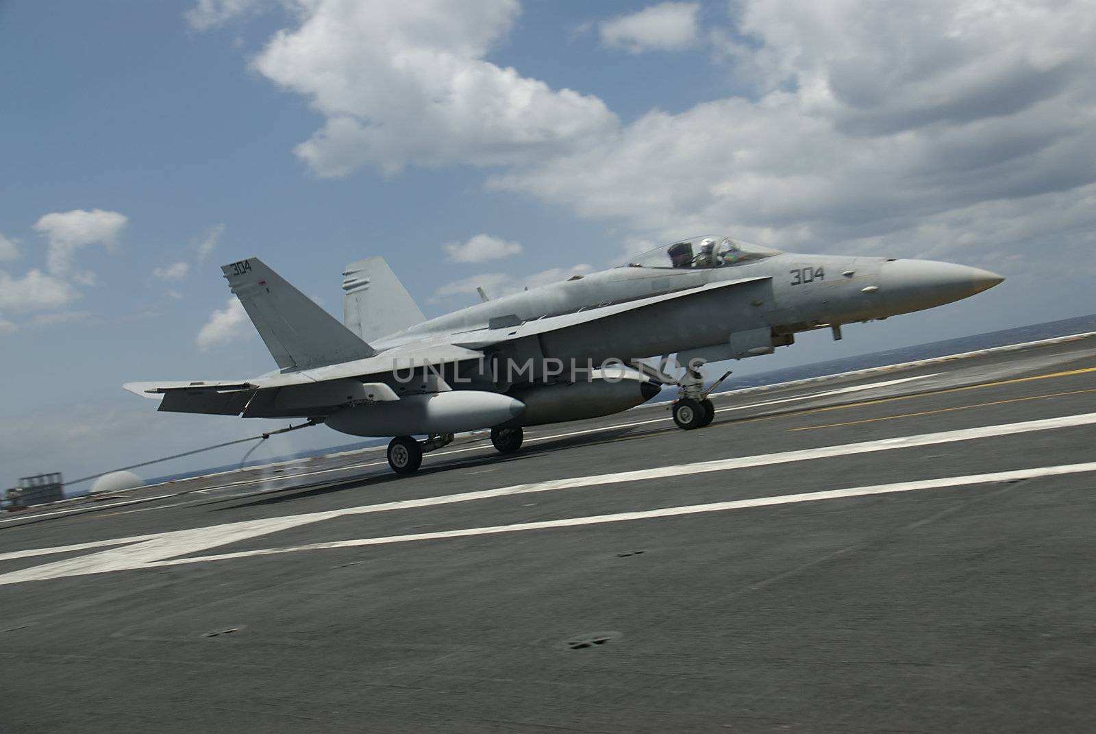 An F-18 Hornet traps aboard a nuclear power aircraft carrier