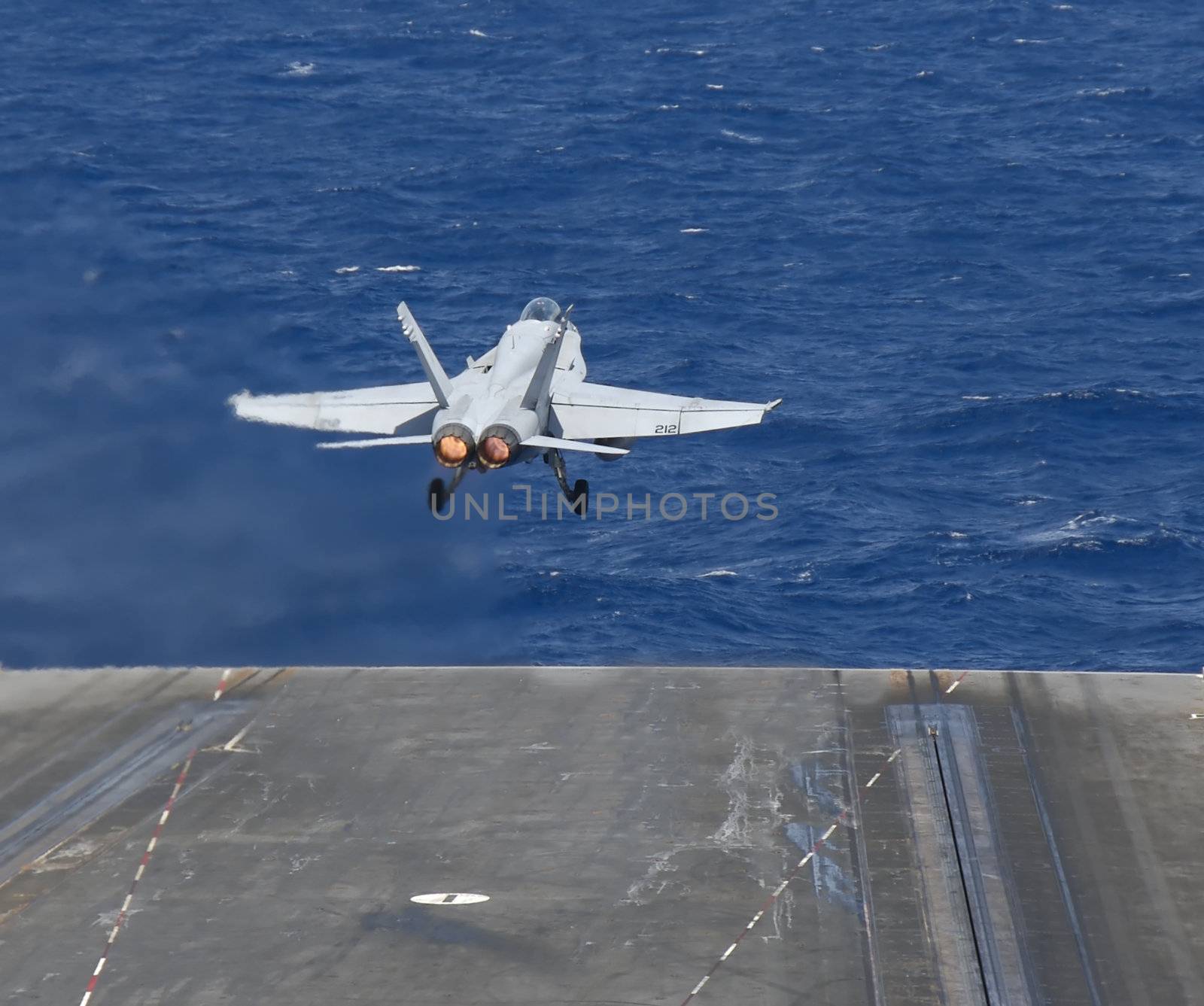 An F-18 Hornet launches from the deck of a nuclear powered aircraft carrier