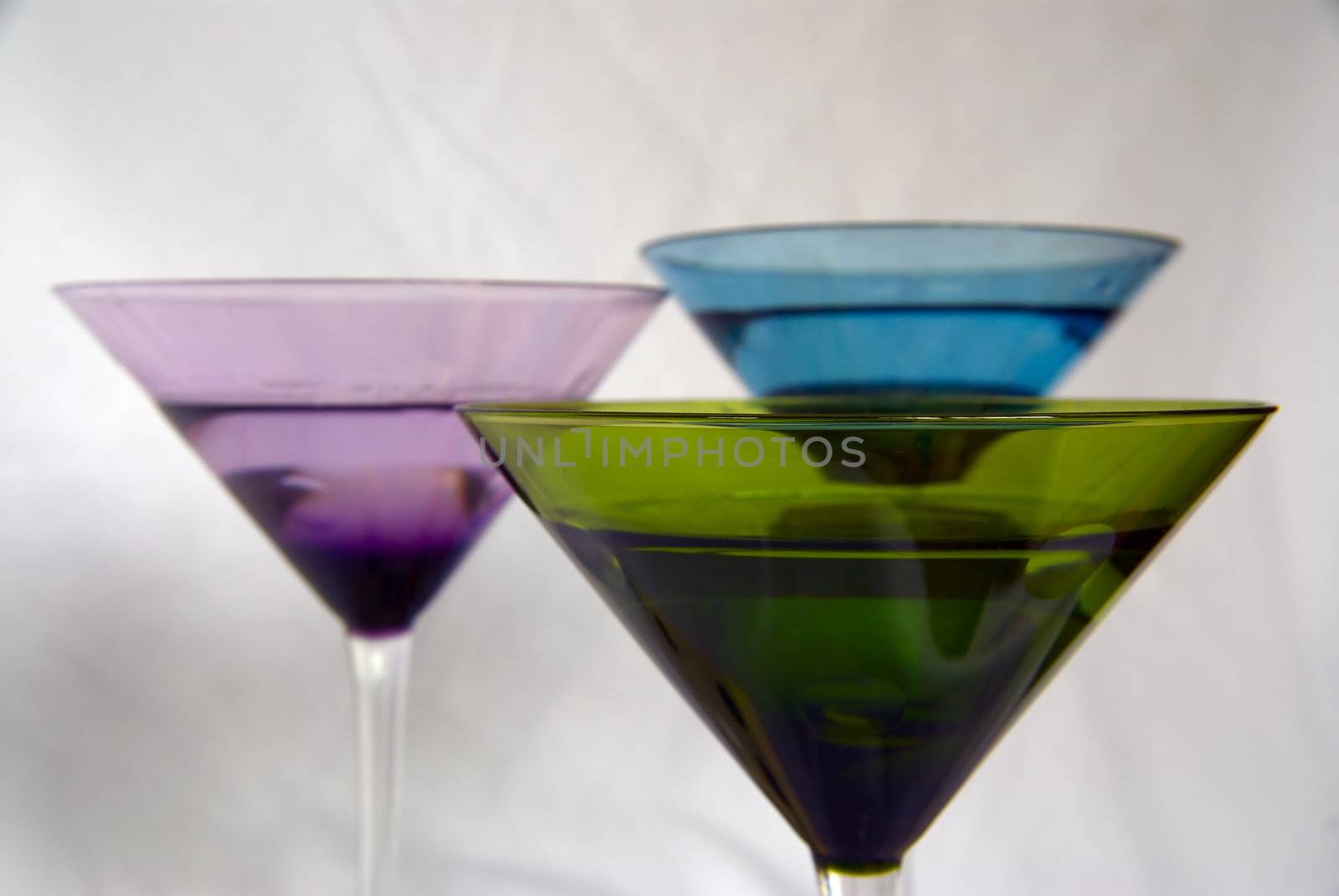 Three colorful martini glasses on a white background with the front glass in focus