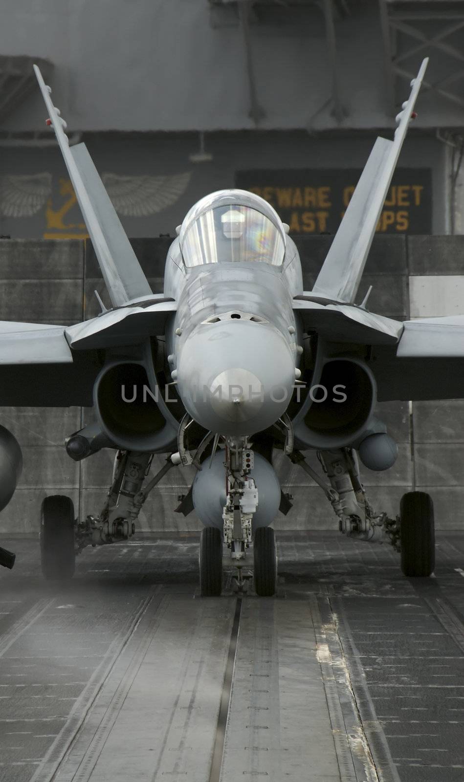 An F-18 Hornet sits ready to launch from a catapult onboard an aircraft carrier