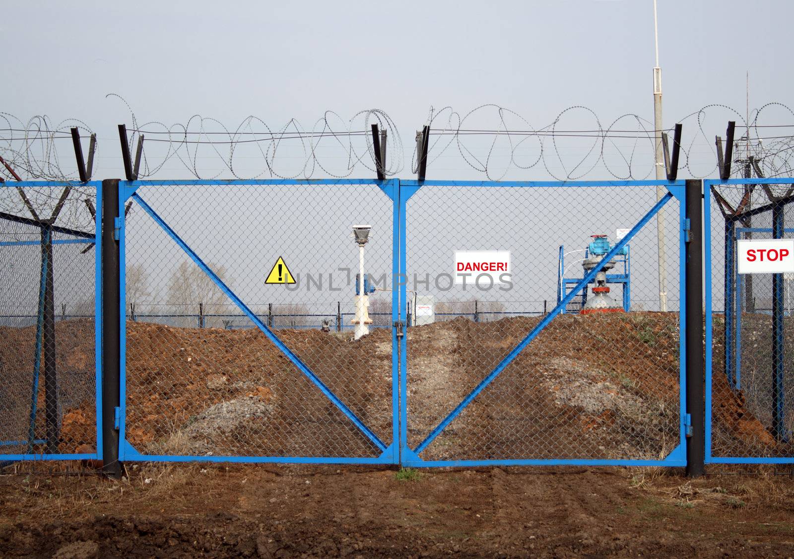 industry danger - locked gate with barbed wire