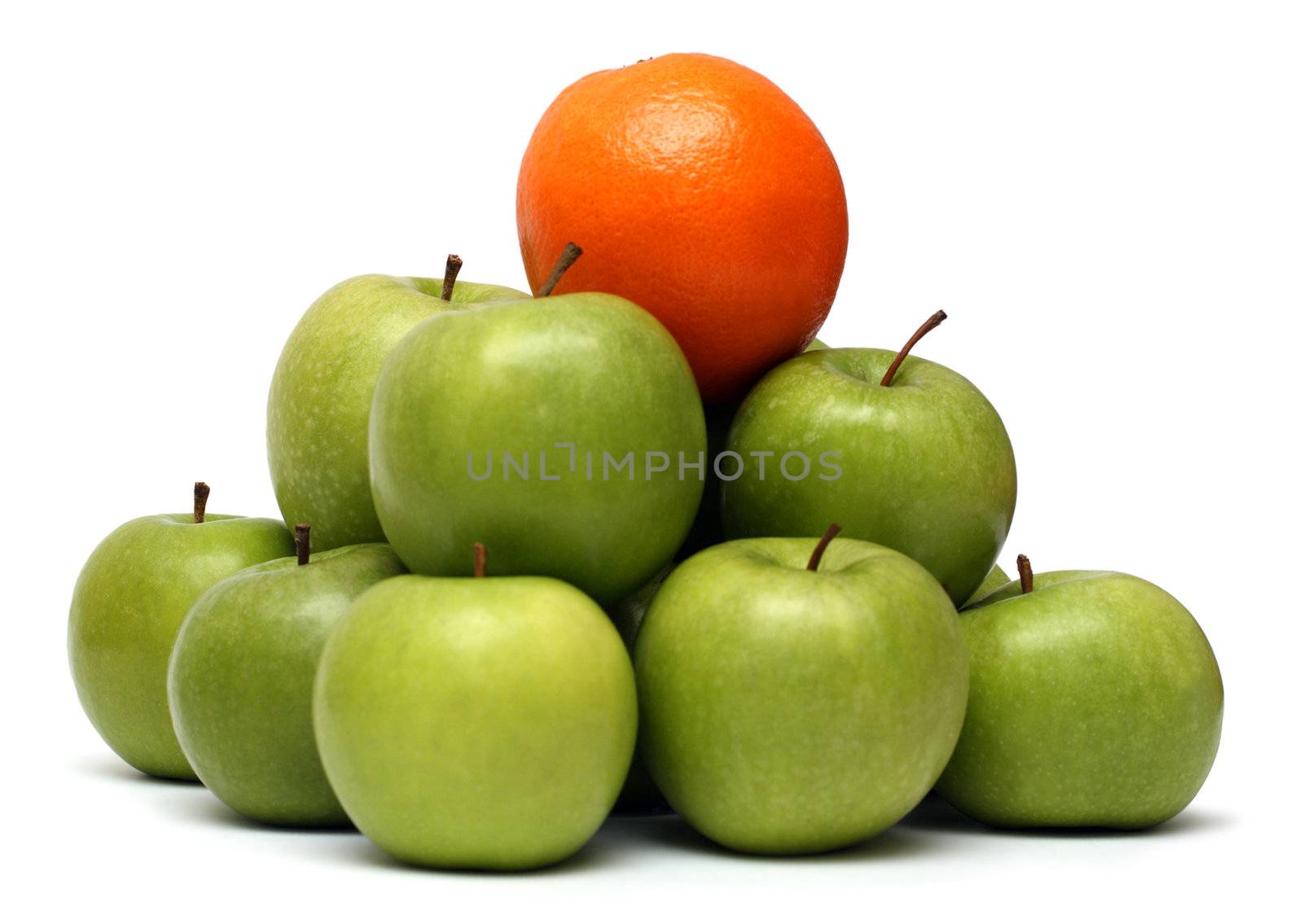 domination concepts - orange on pyramyd of green apples