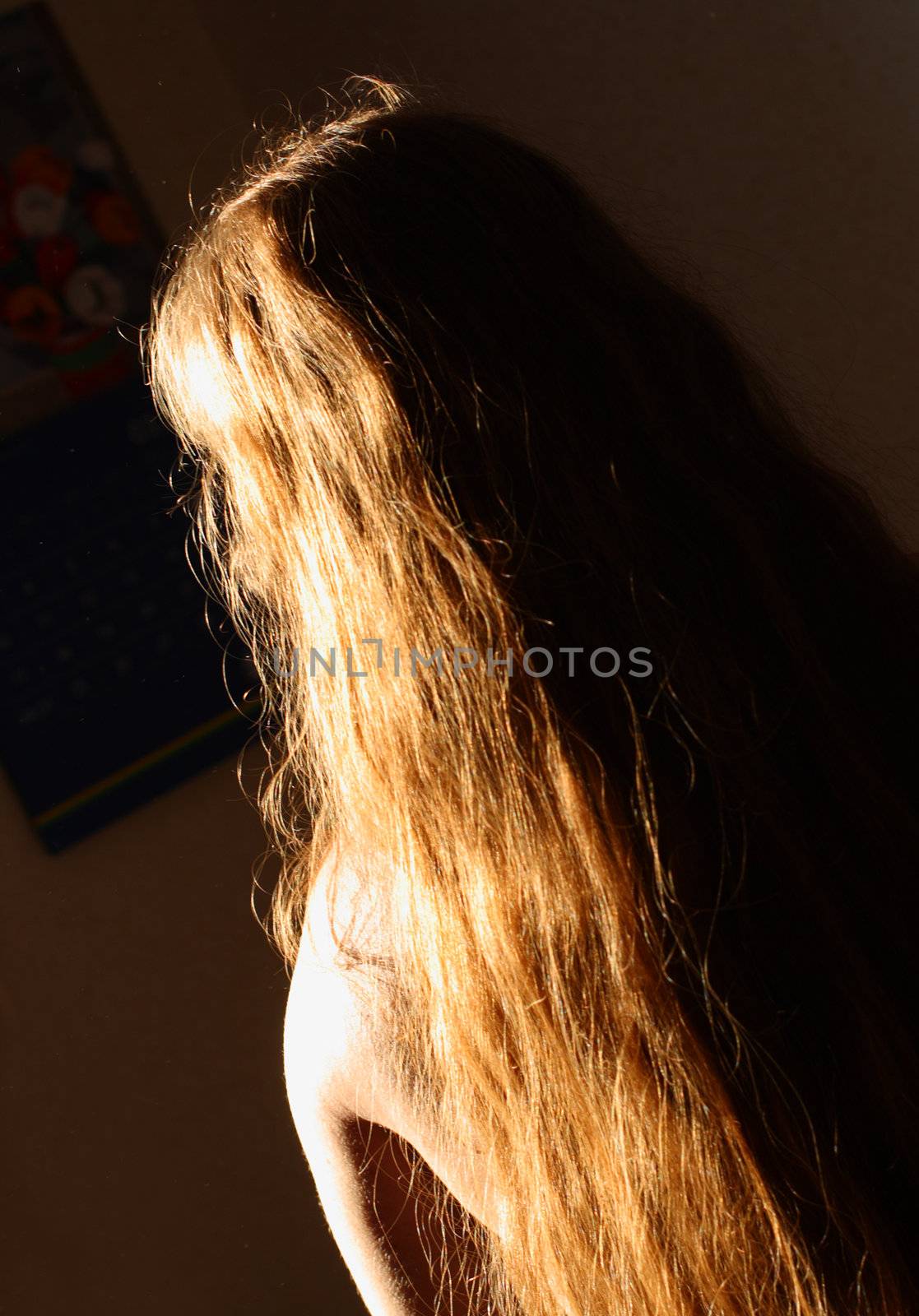 women back with sunlight on beautiful long red hair