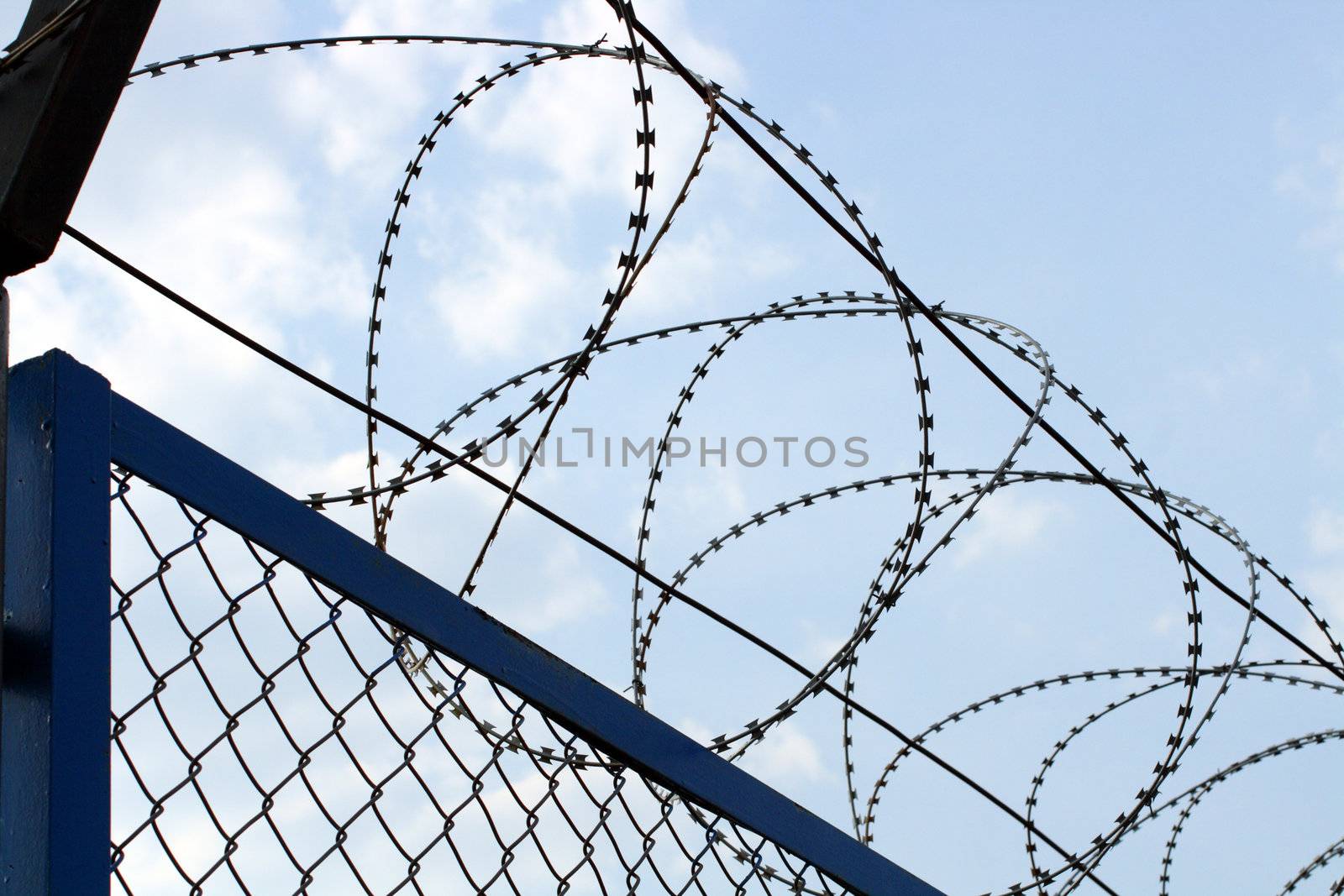fence with barbed wire close-up under blue sky