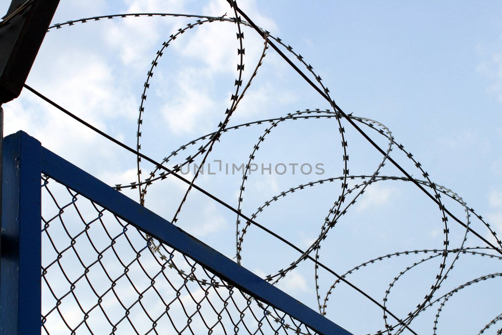 fence with barbed wire close-up under blue sky