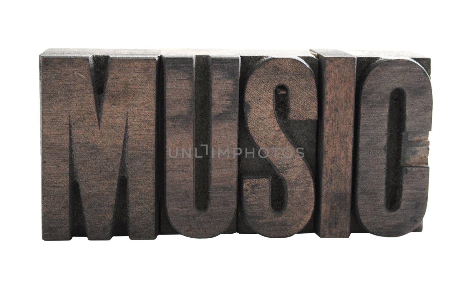 the word 'music' in ink-stained wood letters isolated on white