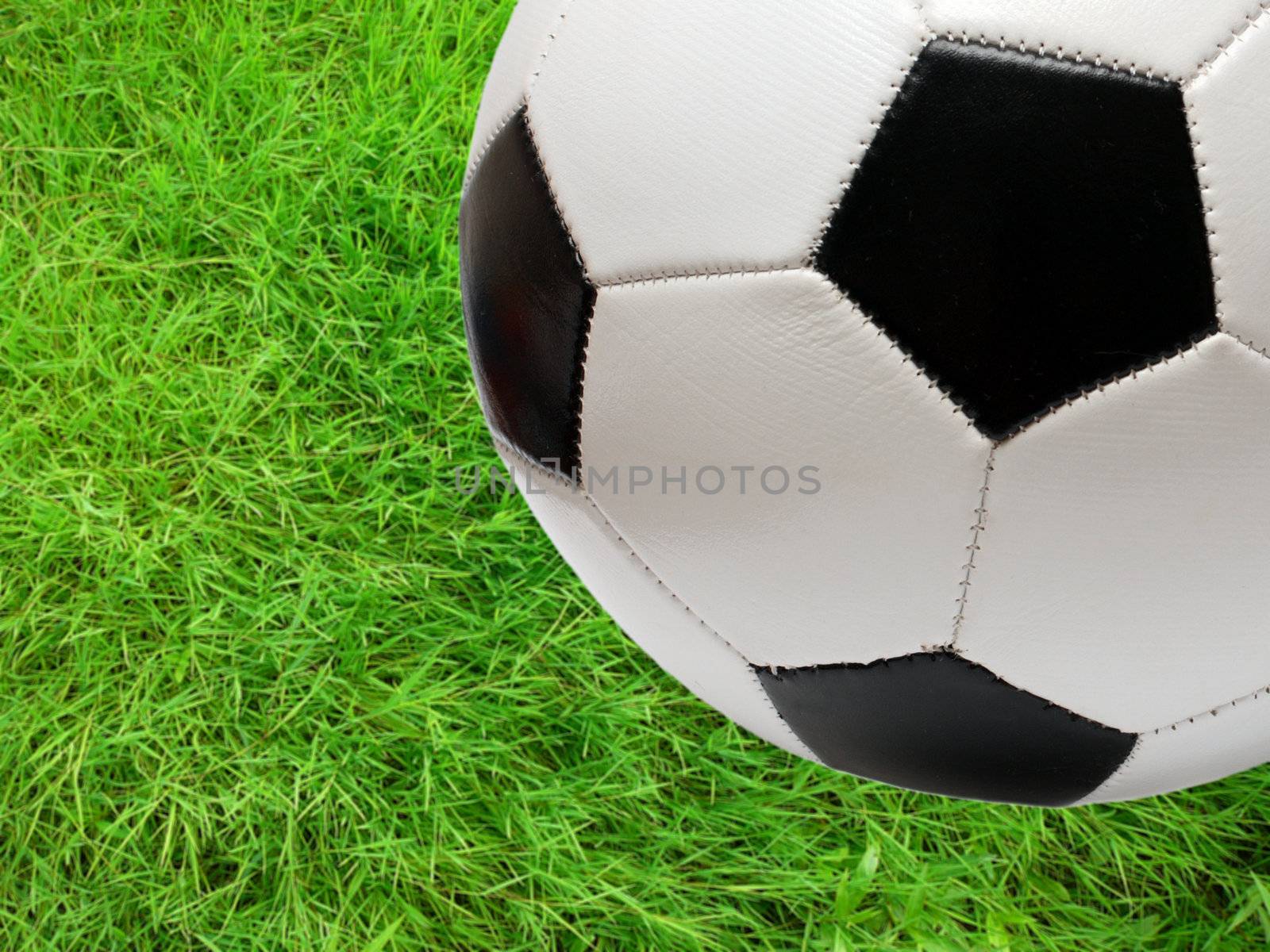 football soccer ball over green grass by Mikko