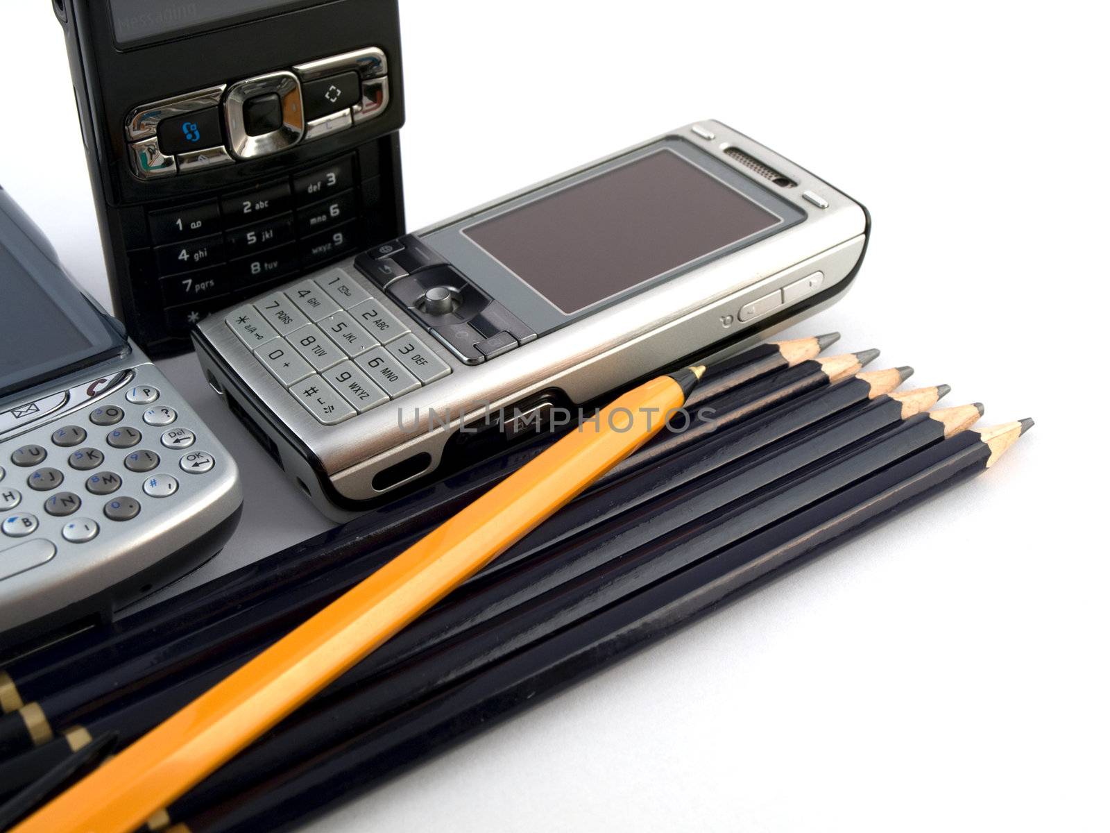 Mobile Phones Pens and Pencils on White Background by bobbigmac