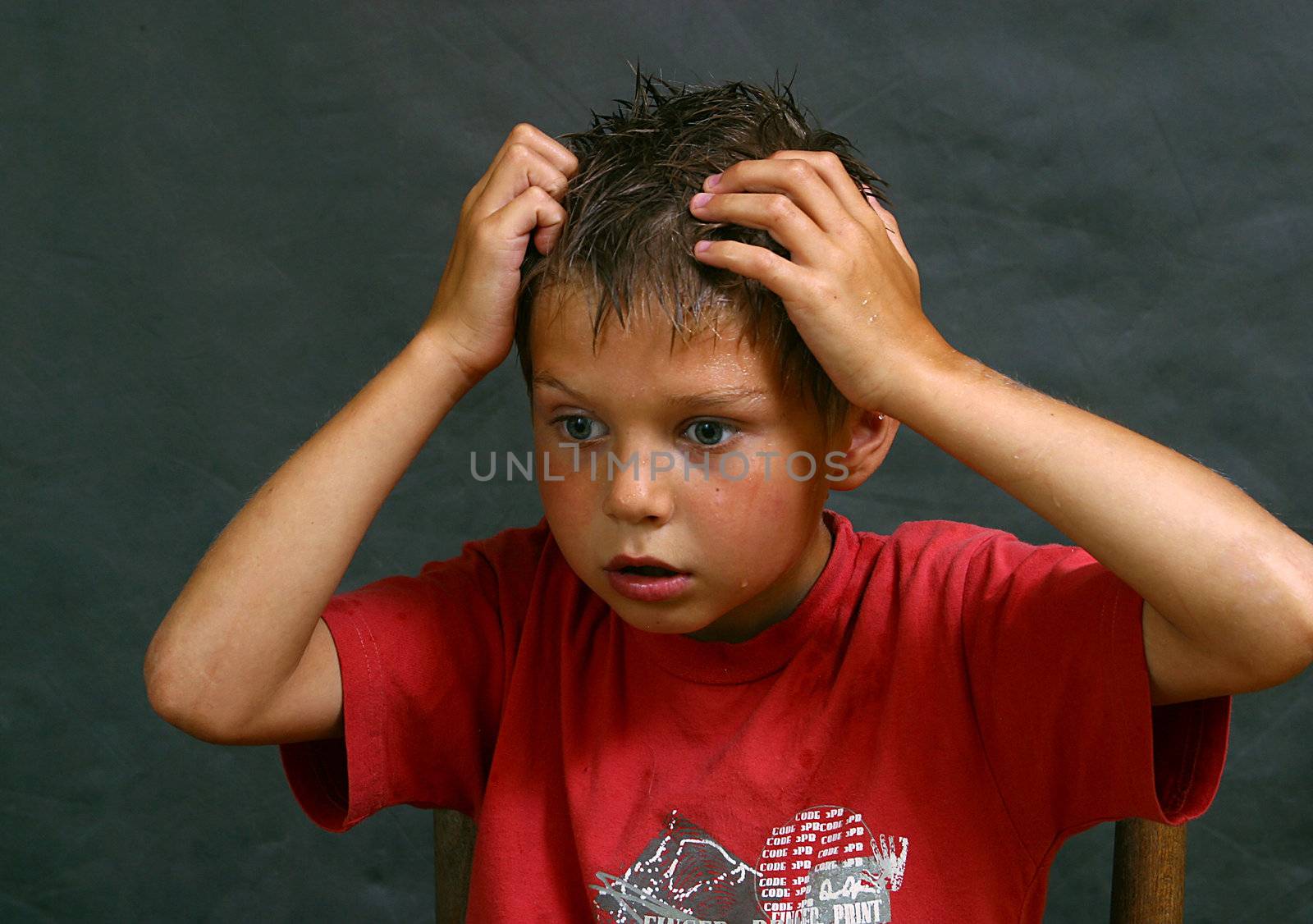 Portrait of the wet boy with hands at a head