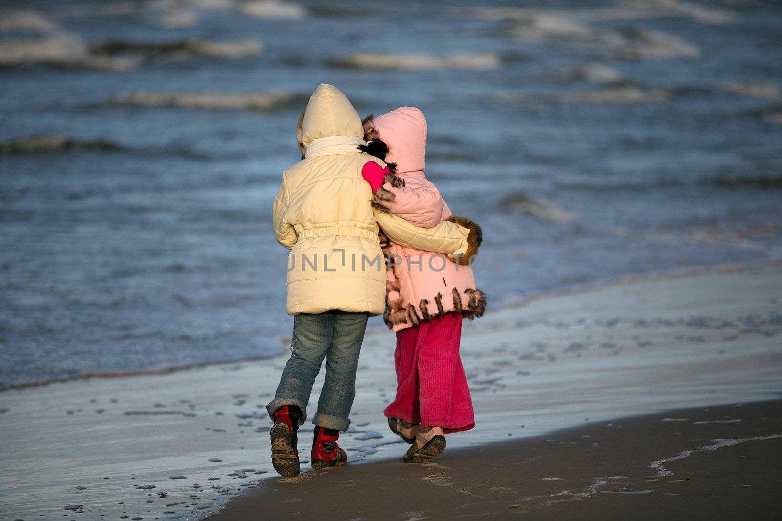 Two girls walk on a coast