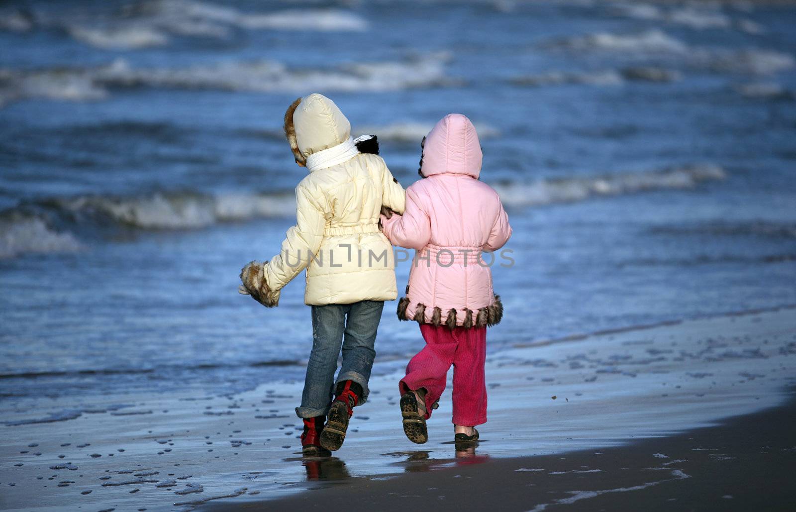 Two girls walk on a coast