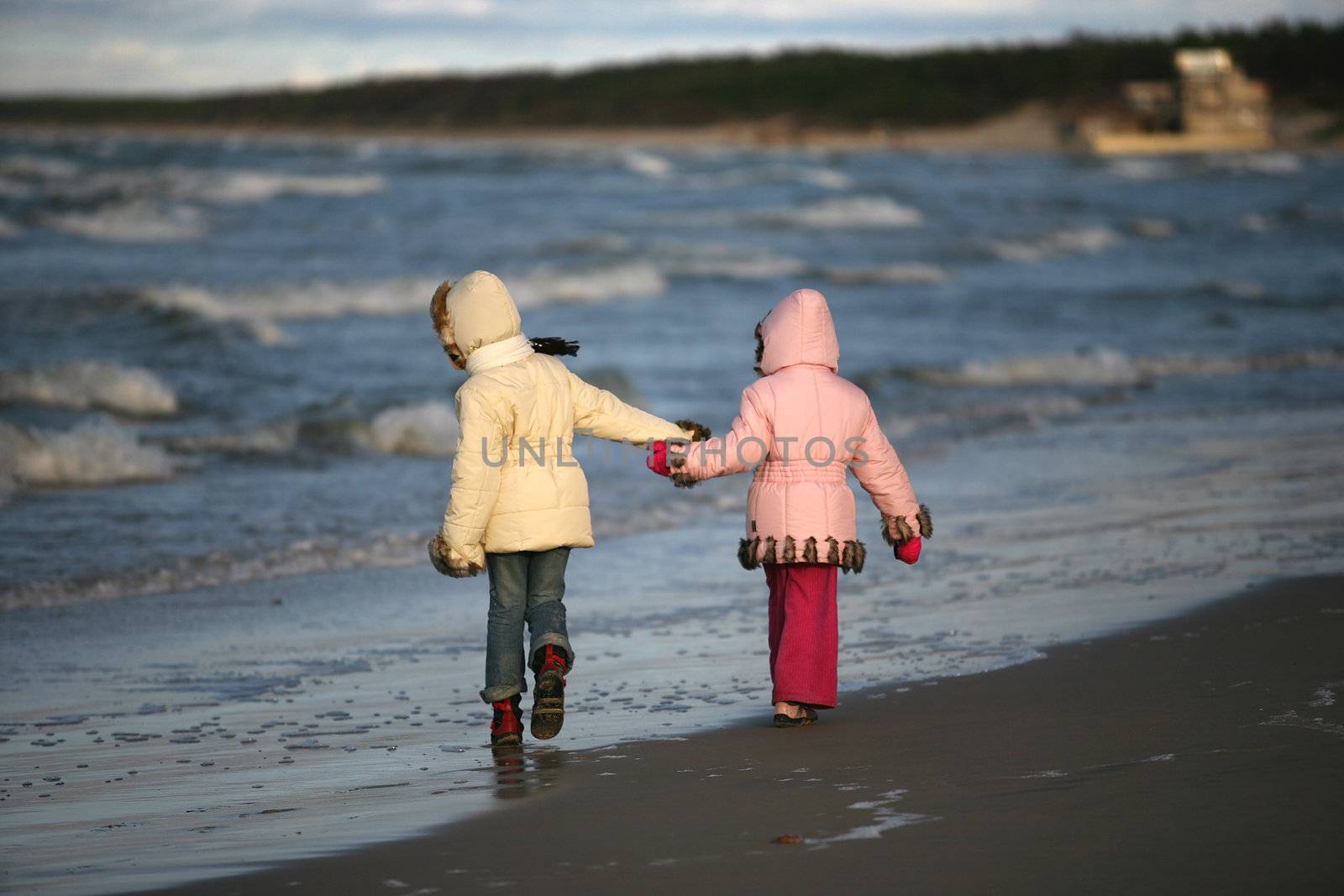 Two girls walk on a coast