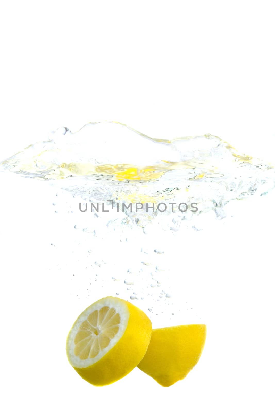 Big yellow lemons splashing in water