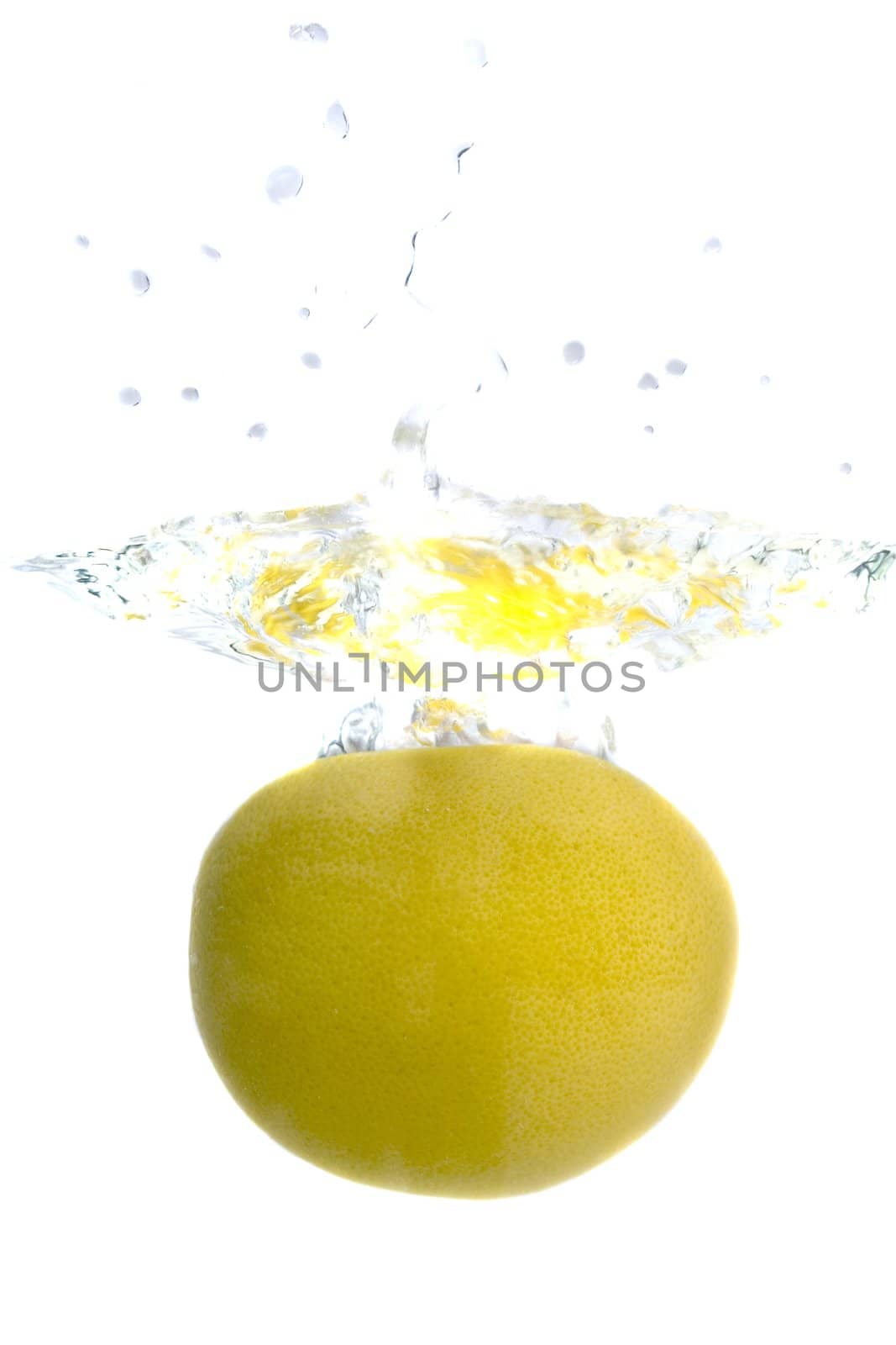 Big yellow lemon splashing in water