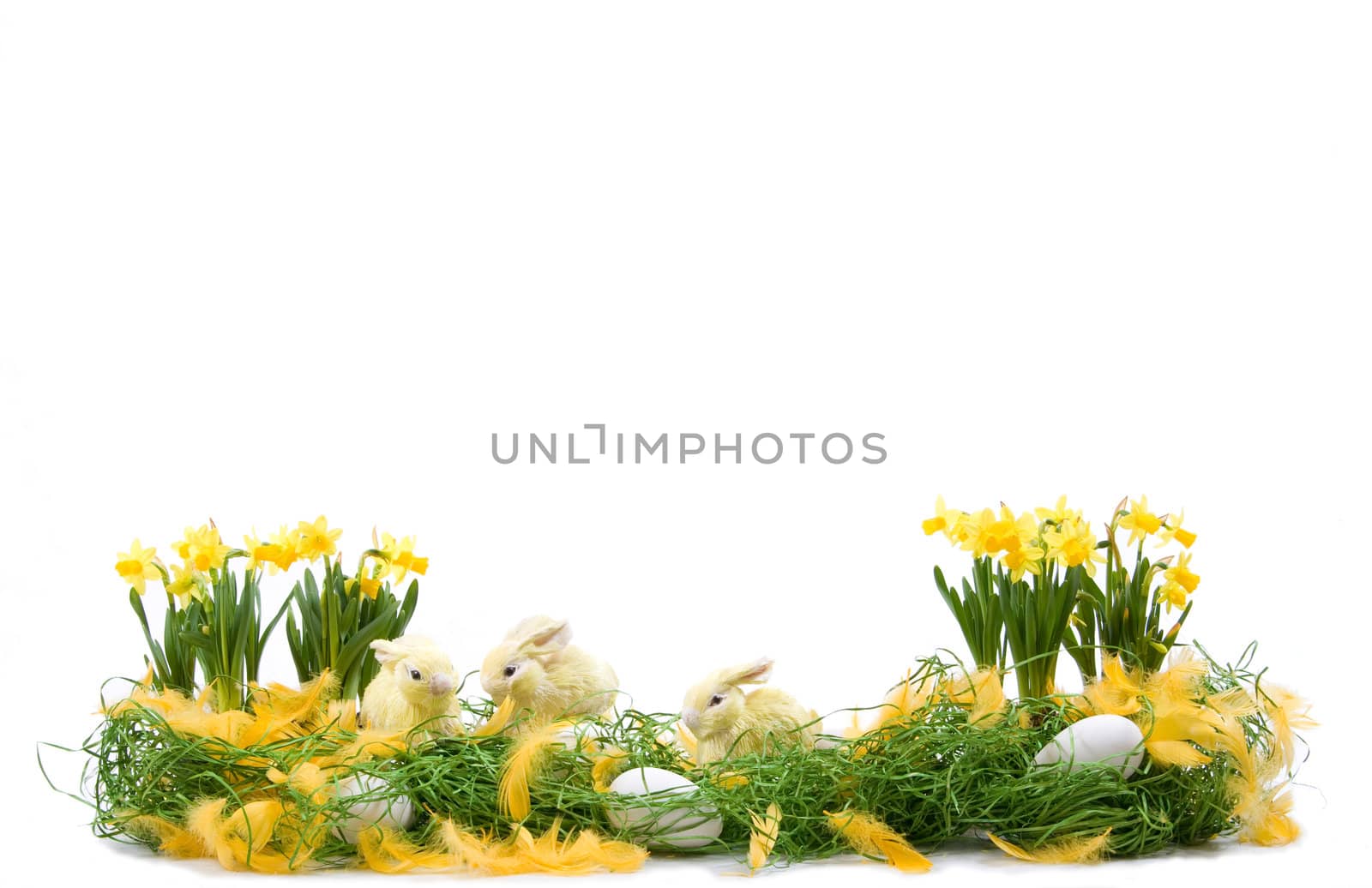 Easter decoration with straw rabbits, eggs and daffodils flowers