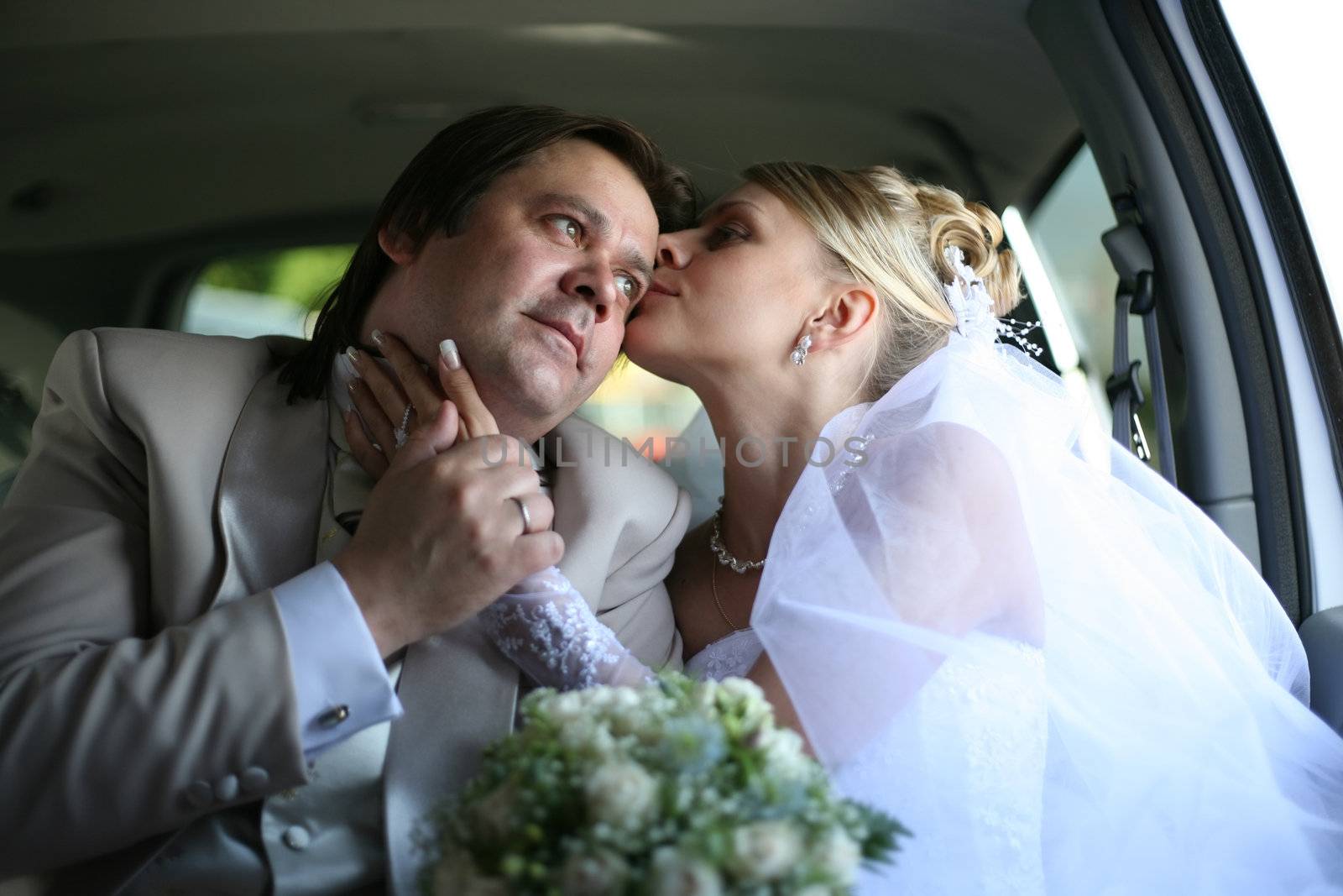 The bride with the groom in the automobile