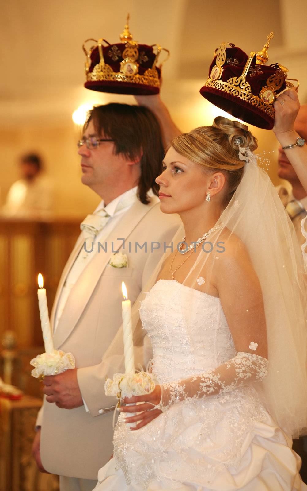 The groom and the bride with candles. Wedding ceremony in church